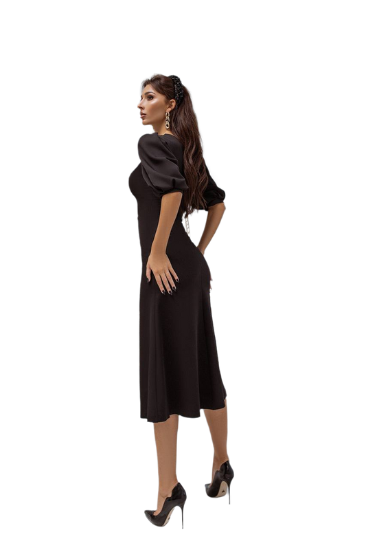 Woman wearing a black dress with puff sleeves on a white background