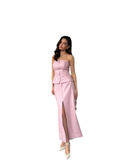 Woman wearing a pink strapless dress with a slit on a white background