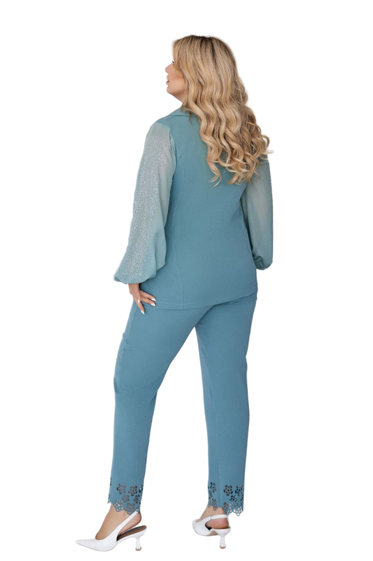 Woman wearing a teal outfit with a matching top and pants on a white background
