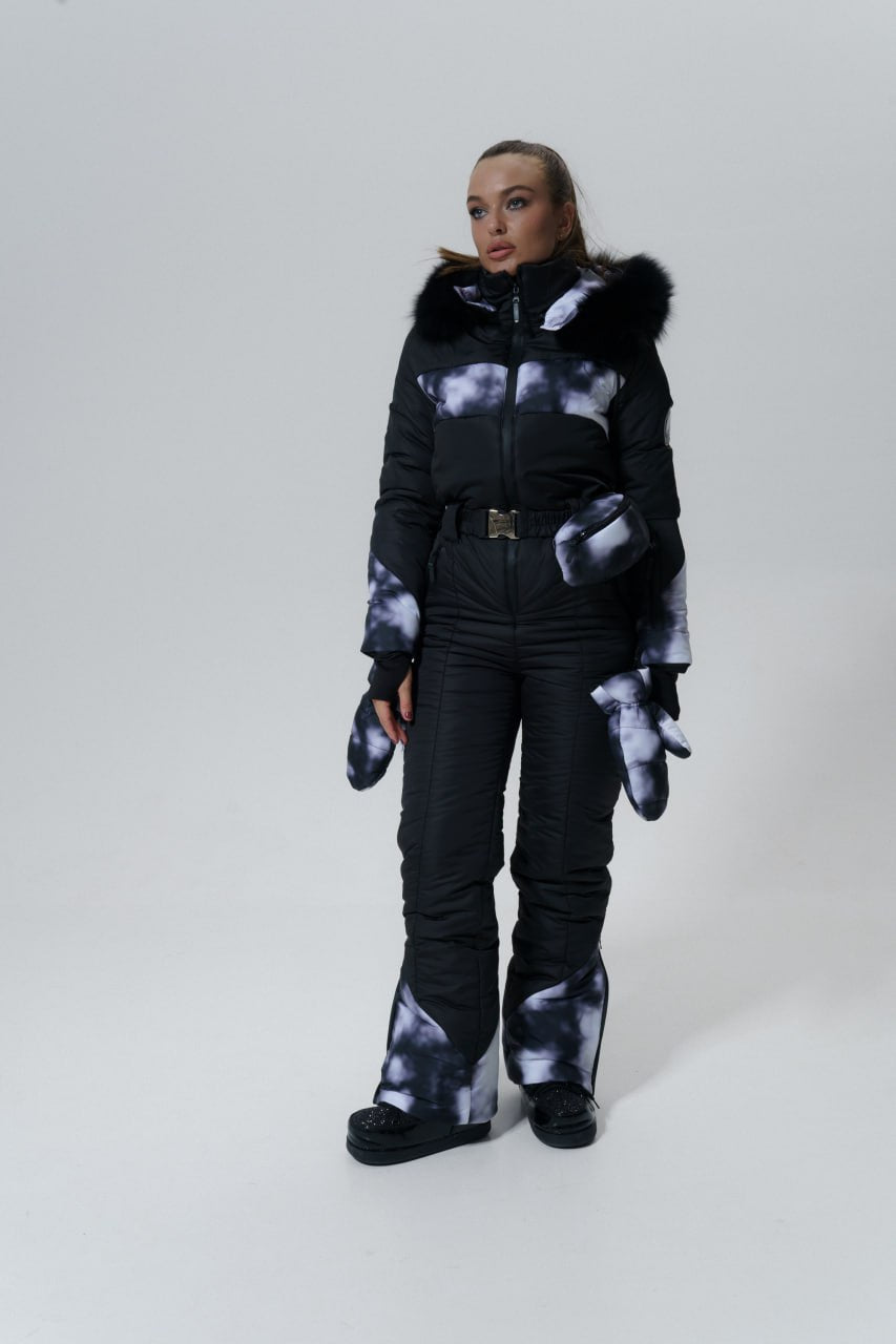 Person wearing a black snowsuit with gray pattern on a white background