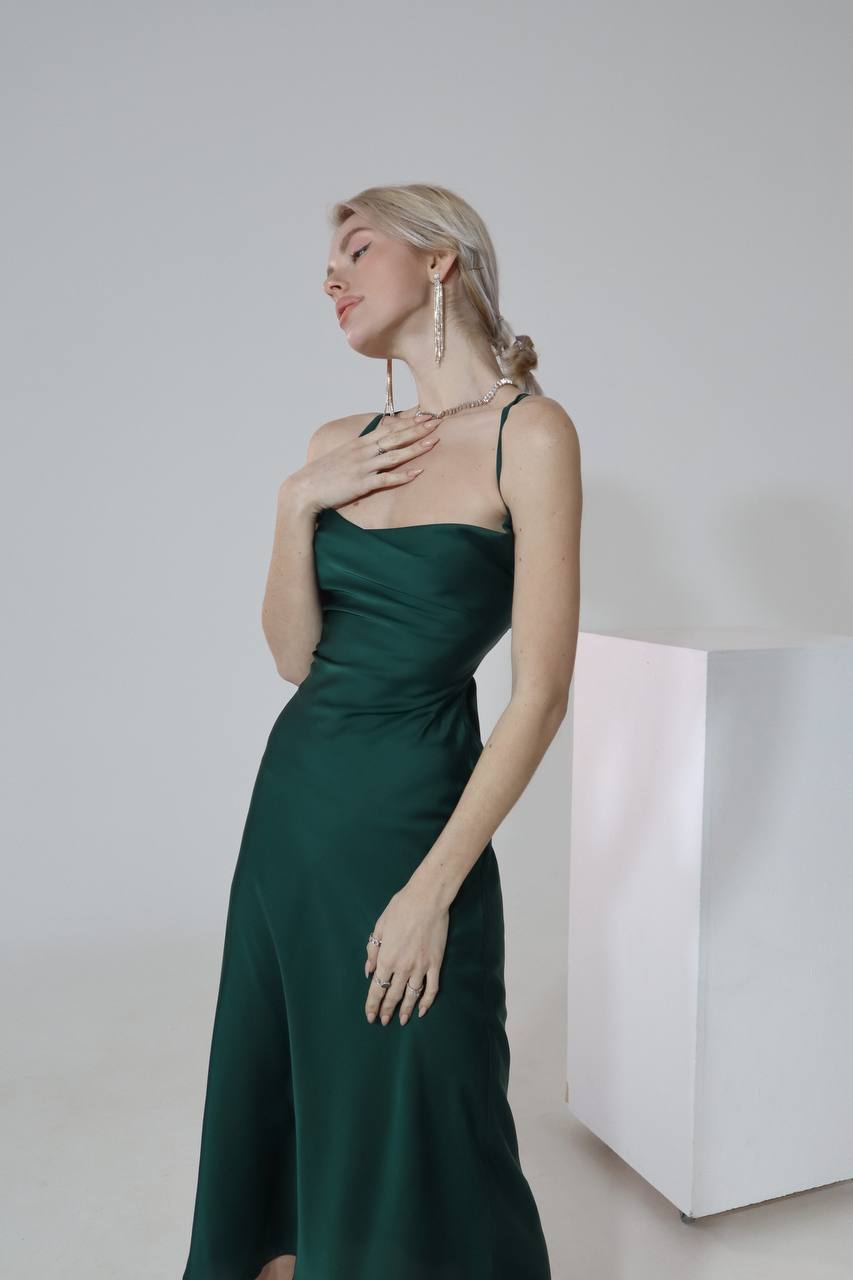 Woman wearing a green dress against a plain background