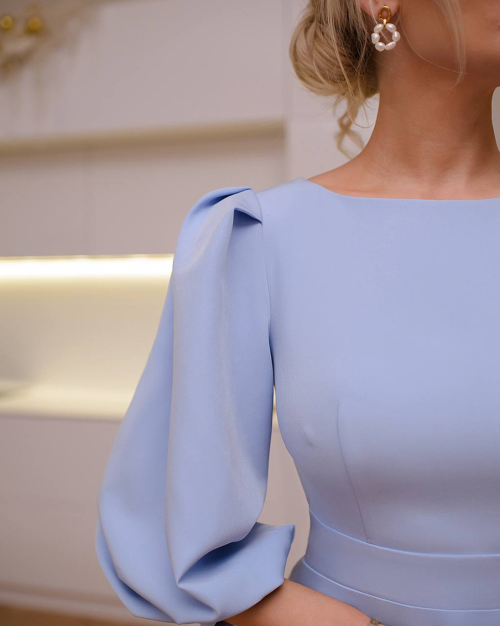 Light blue dress with long sleeves and a blurred background