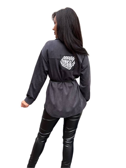 Person wearing a dark gray long-sleeve shirt with a logo on the back, standing against a white background.