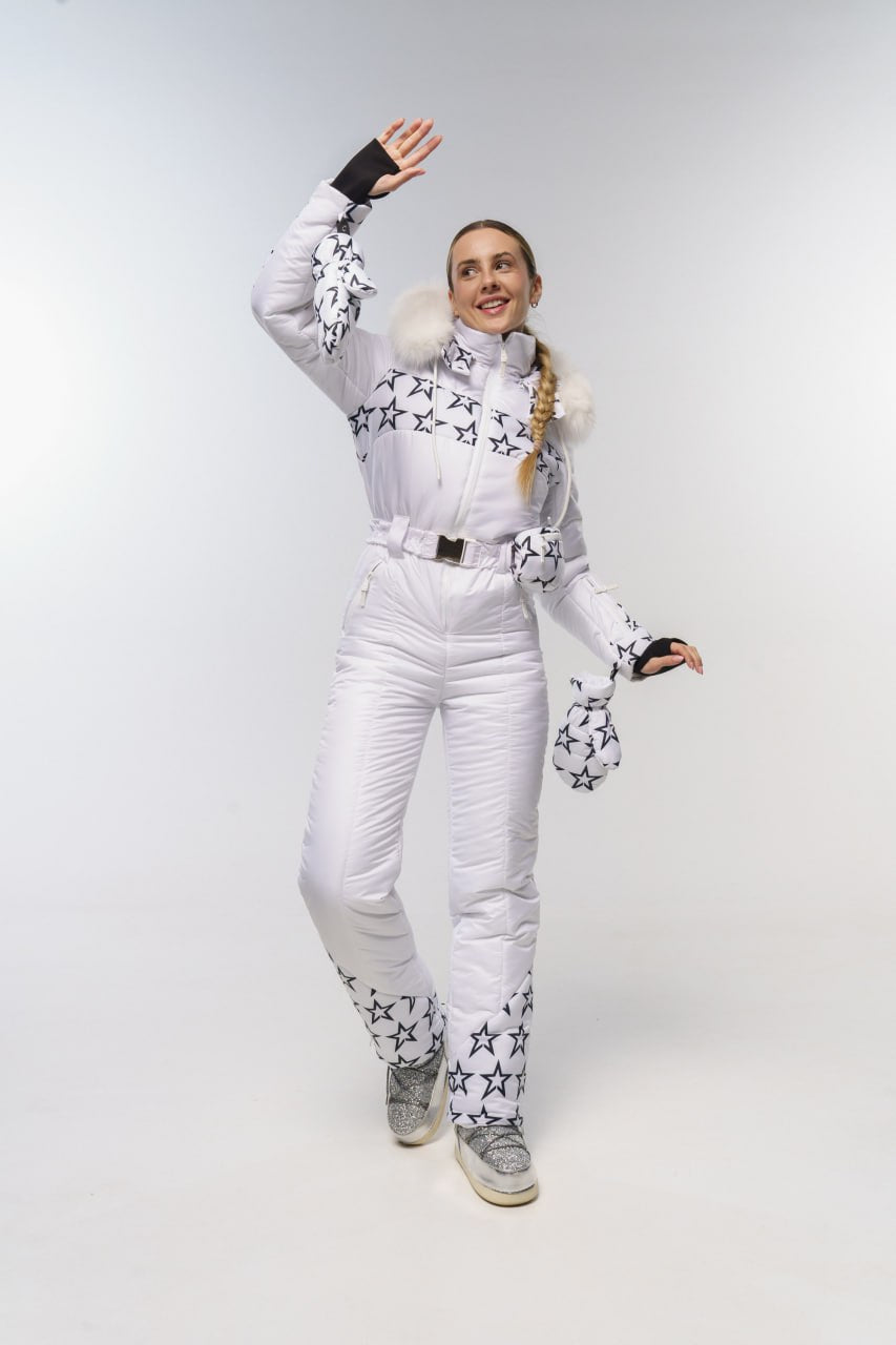 Person wearing a white snowsuit with star patterns on a plain background