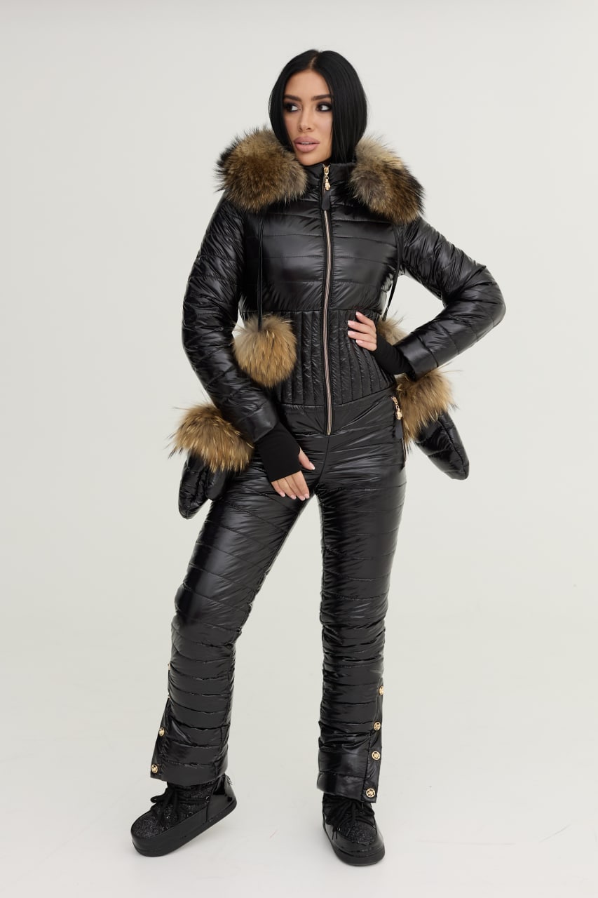 Person wearing a black snowsuit with fur trim on a white background