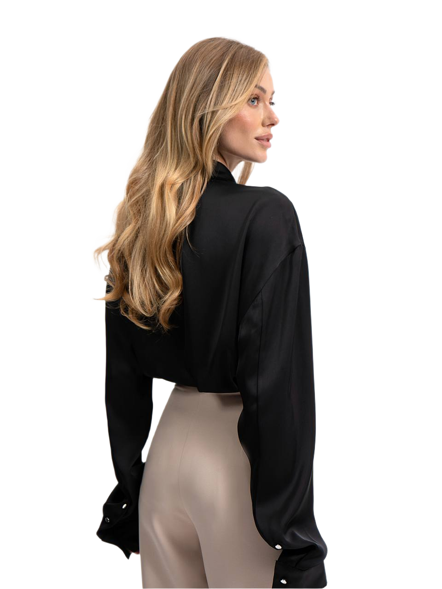 Woman wearing a black blouse and beige pants on a white background