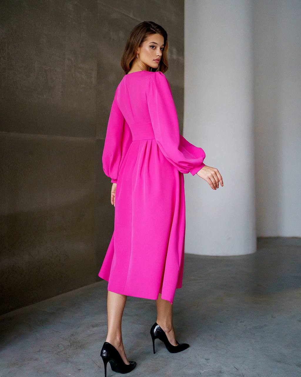 Woman wearing a bright pink dress in an indoor setting