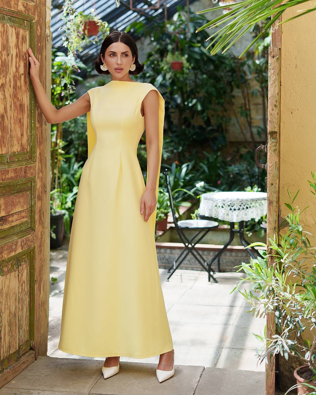 Woman in a yellow dress standing in a garden setting