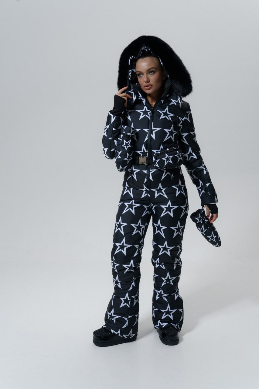 Person wearing a black and white star-patterned snowsuit on a white background