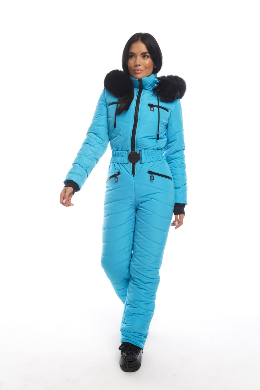 Woman wearing a blue snowsuit with black fur trim on a white background
