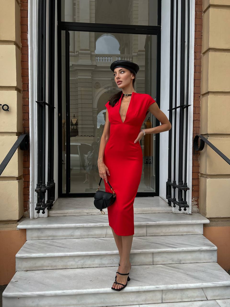 Woman in a red dress standing on steps outside a building