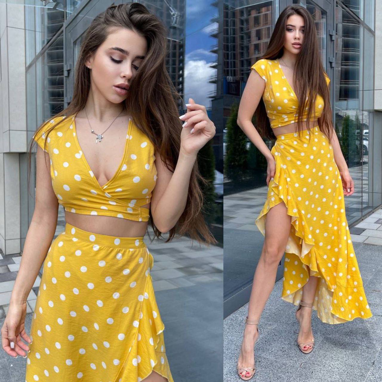 Woman wearing a yellow polka dot dress in an urban setting