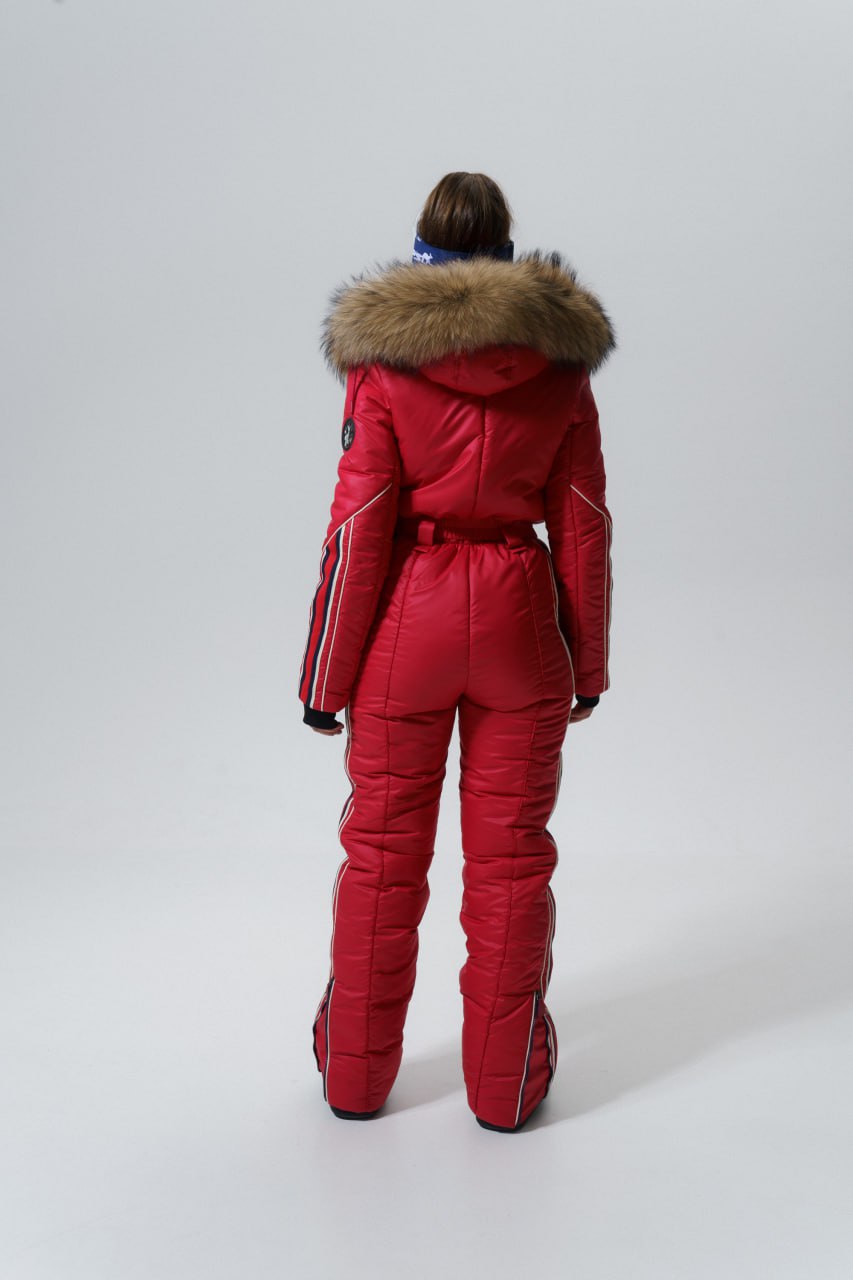 Person wearing a red snowsuit with fur hood on a white background