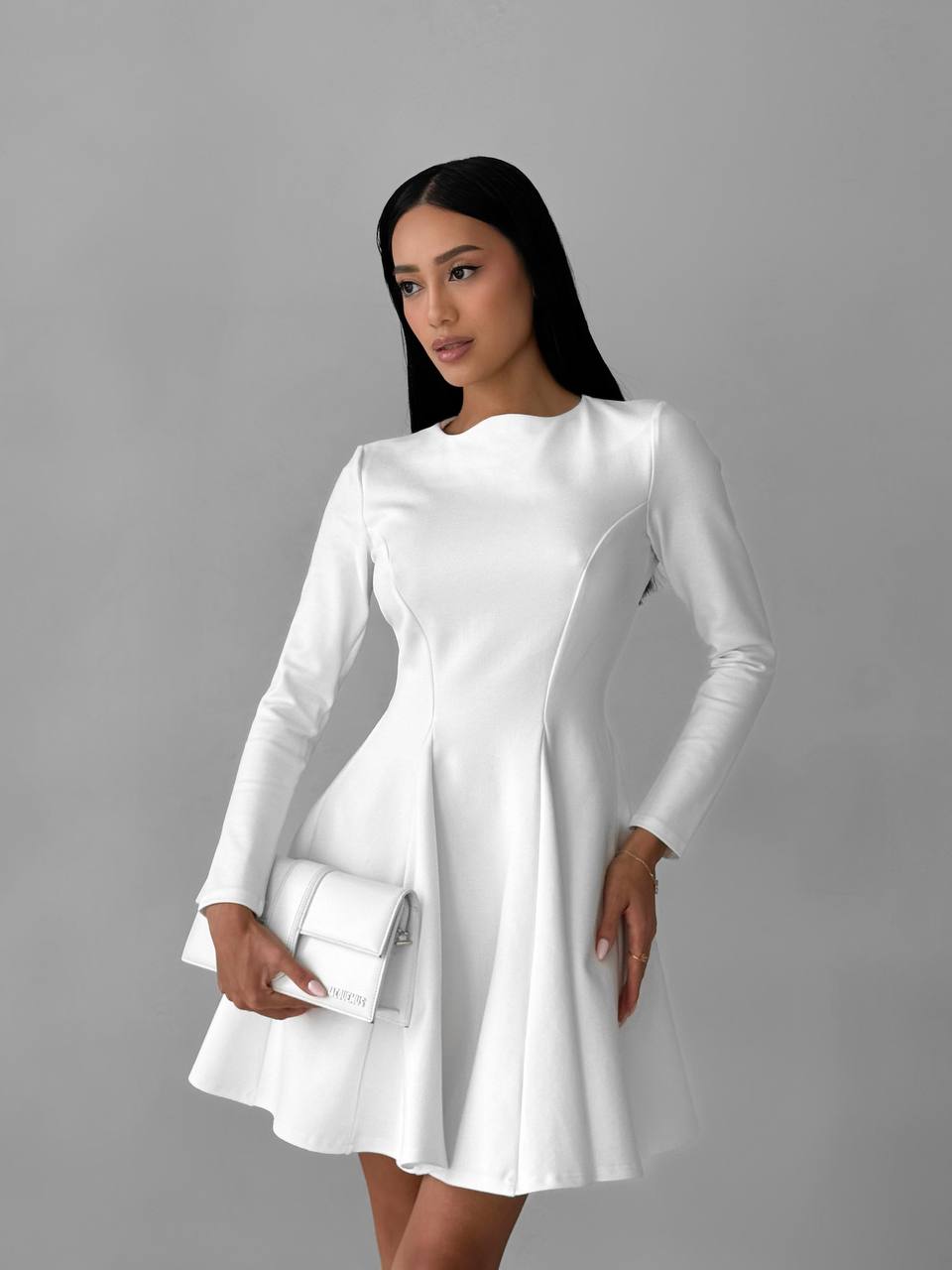 Woman wearing a white dress against a gray background