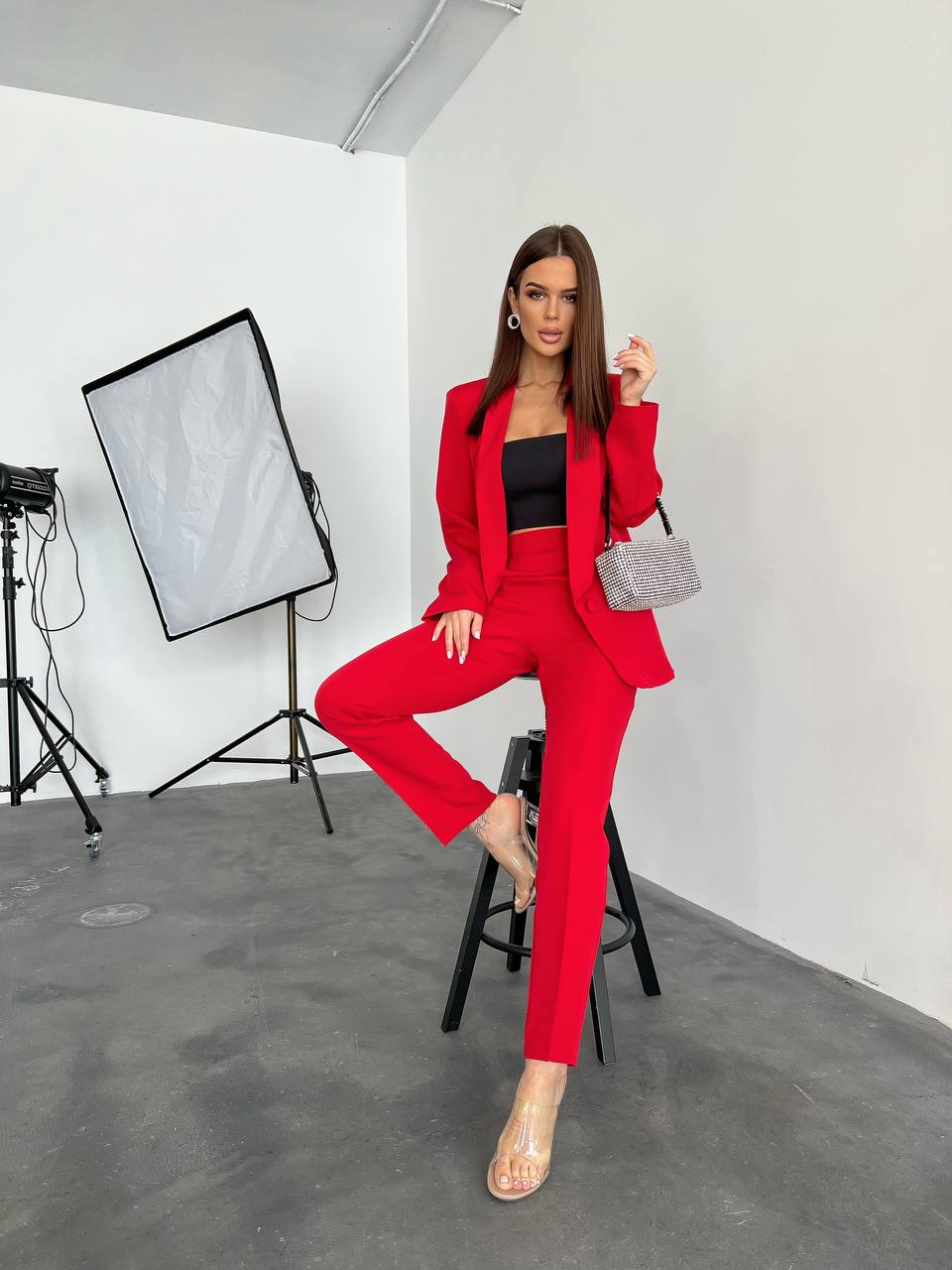 Woman in a red suit posing in a studio setting