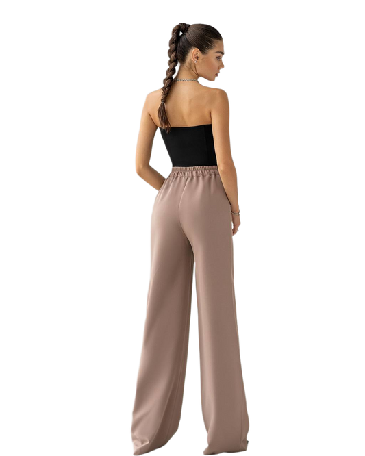 Woman wearing a black top and beige wide-leg pants on a white background