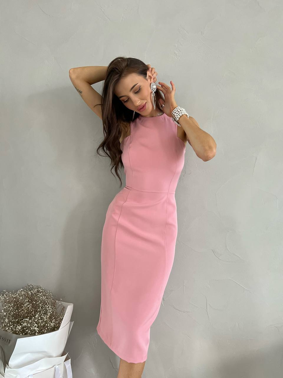 Woman wearing a pink dress against a plain background