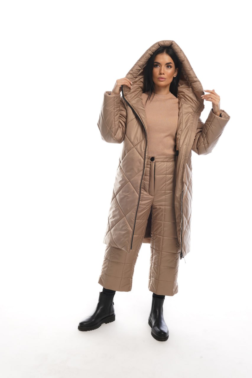 Woman wearing a beige quilted coat on a white background
