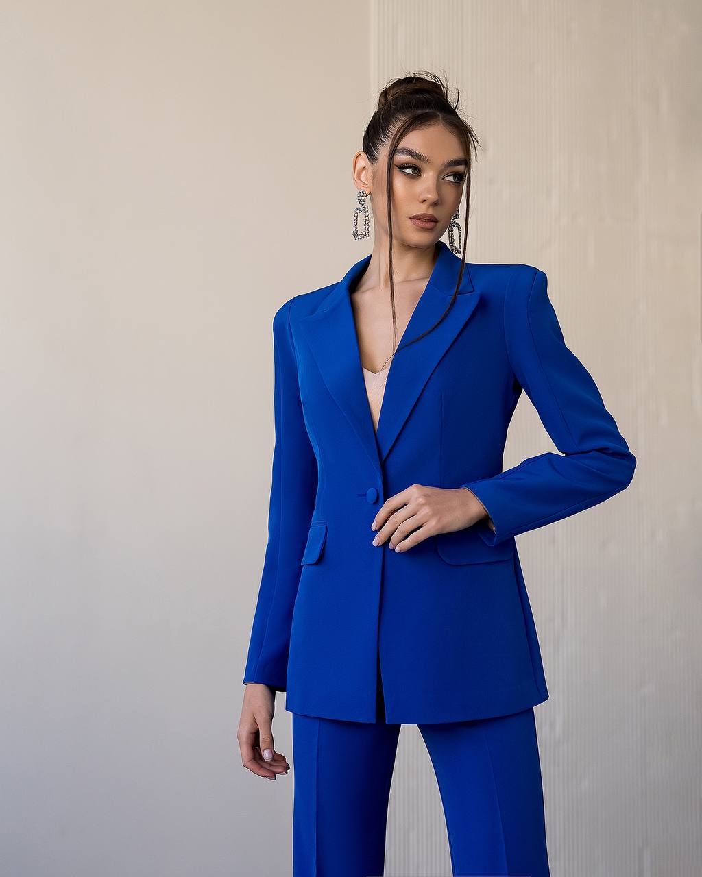 Woman wearing a blue suit against a plain background