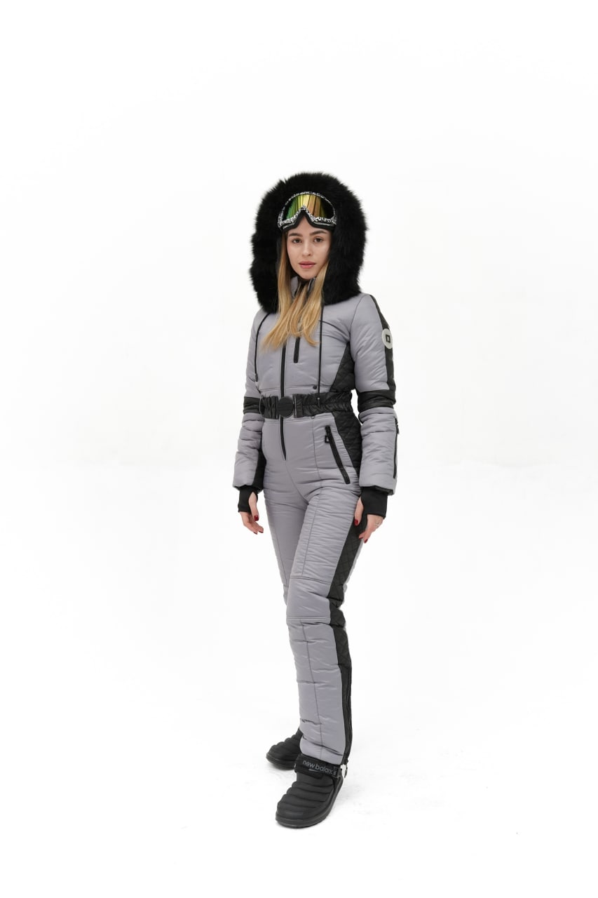 Person wearing a gray and black winter suit with a hood on a white background