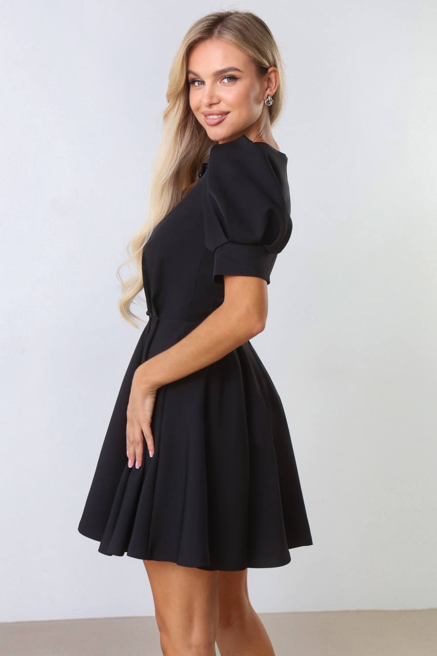 Woman wearing a black dress against a white background