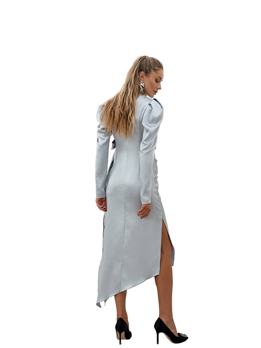 Woman wearing a long, light gray dress with a high slit on a white background