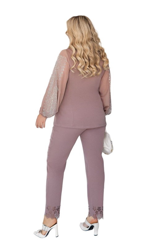 Woman wearing a mauve outfit with sheer sleeves on a white background
