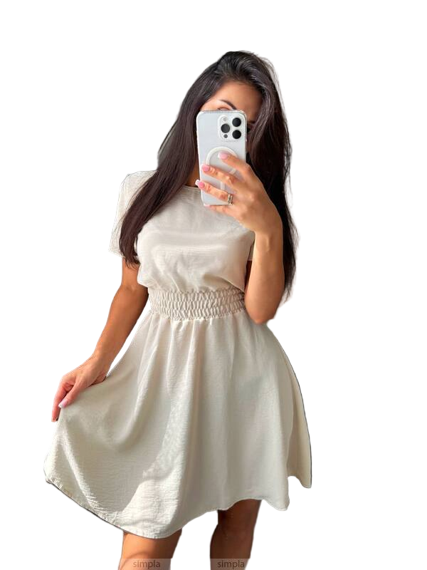 Woman wearing a white dress taking a mirror selfie on a plain background