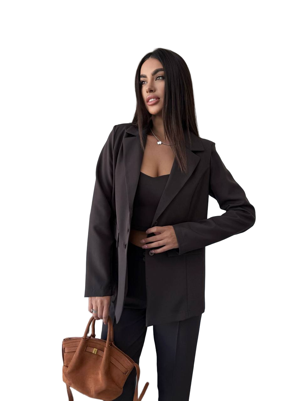 Woman wearing a dark suit holding a brown handbag on a white background