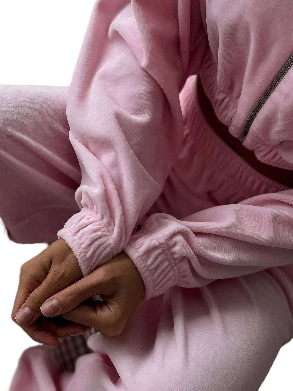 Person wearing a pink tracksuit with a close-up of the jacket and pants.