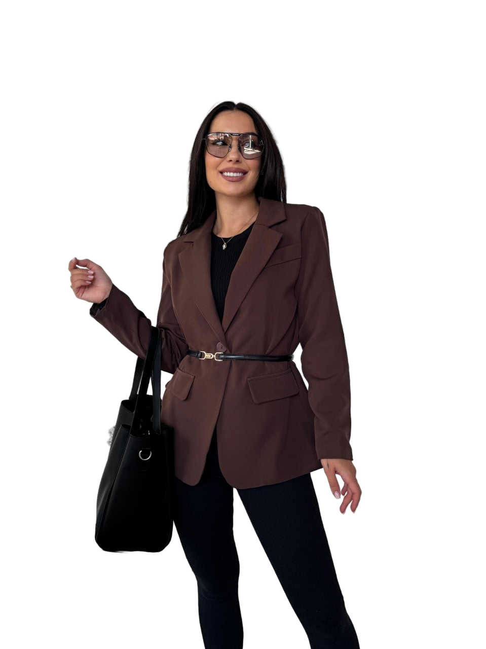 Woman wearing a brown blazer and black pants with a black handbag on a white background