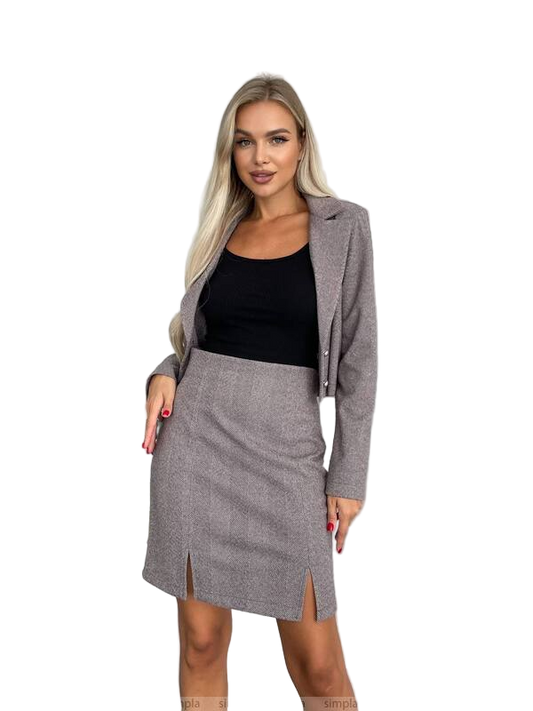 Woman wearing a gray blazer and skirt set on a white background