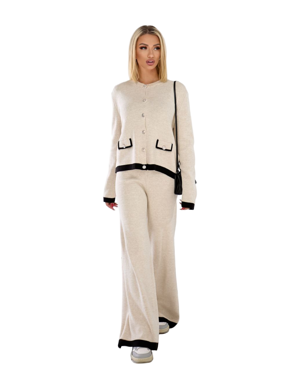 Woman wearing a beige outfit with black accents on a white background