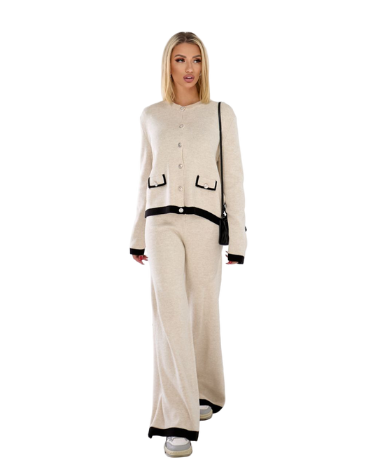 Woman wearing a beige outfit with black accents on a white background