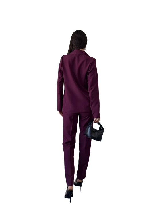 Person wearing a purple suit holding a black handbag on a white background