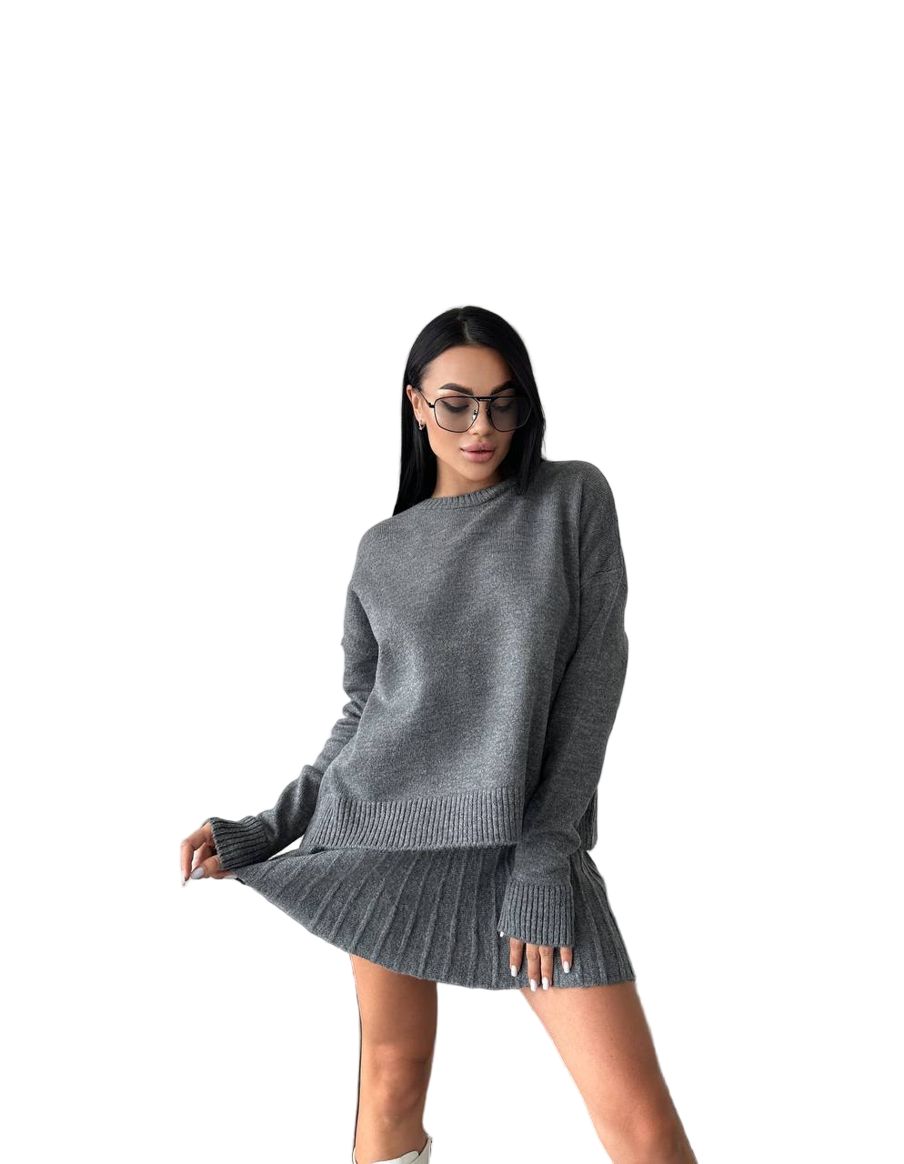 Woman wearing a gray sweater and skirt set on a white background
