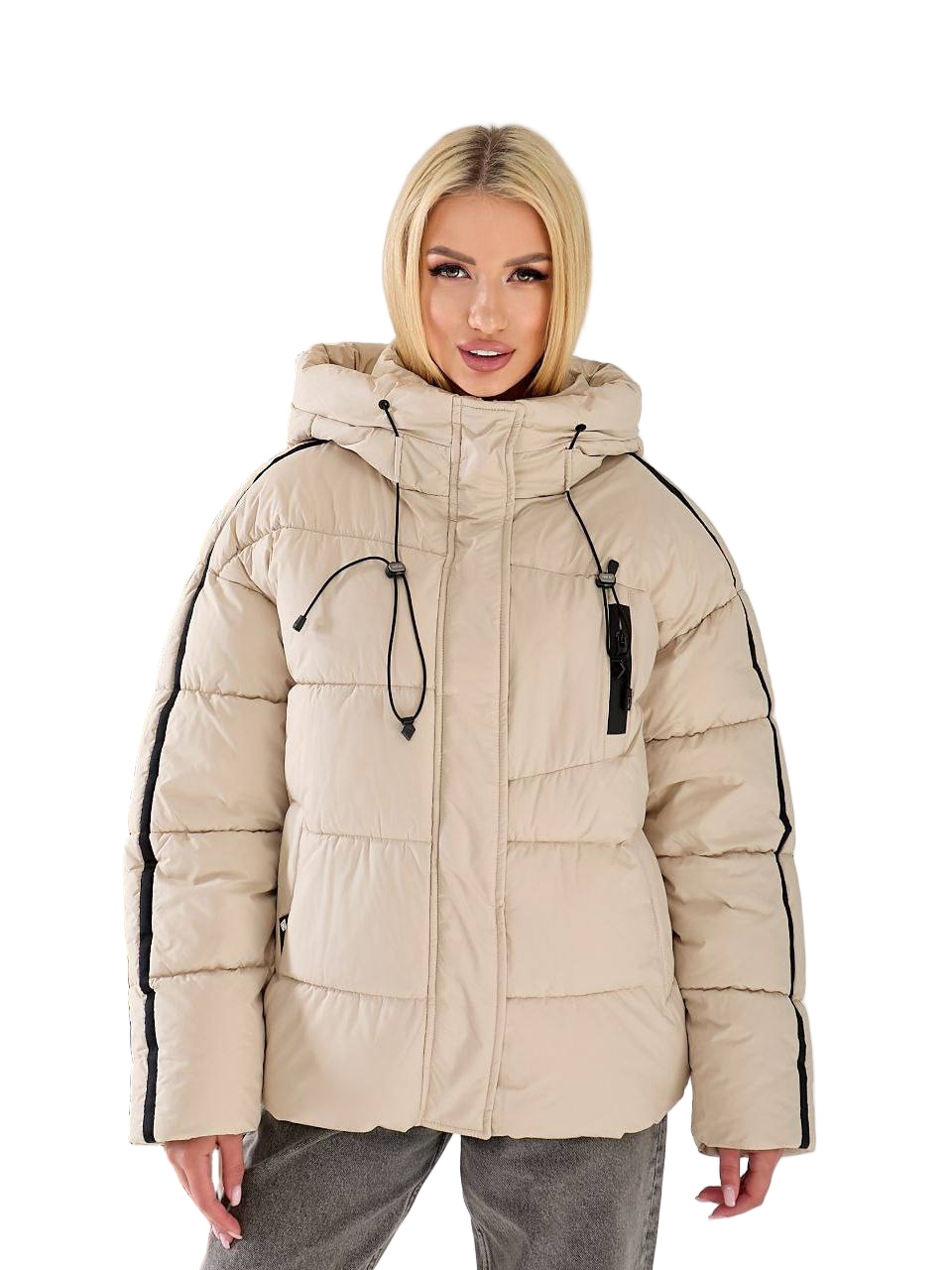 Woman wearing a beige puffer jacket with black accents on a white background