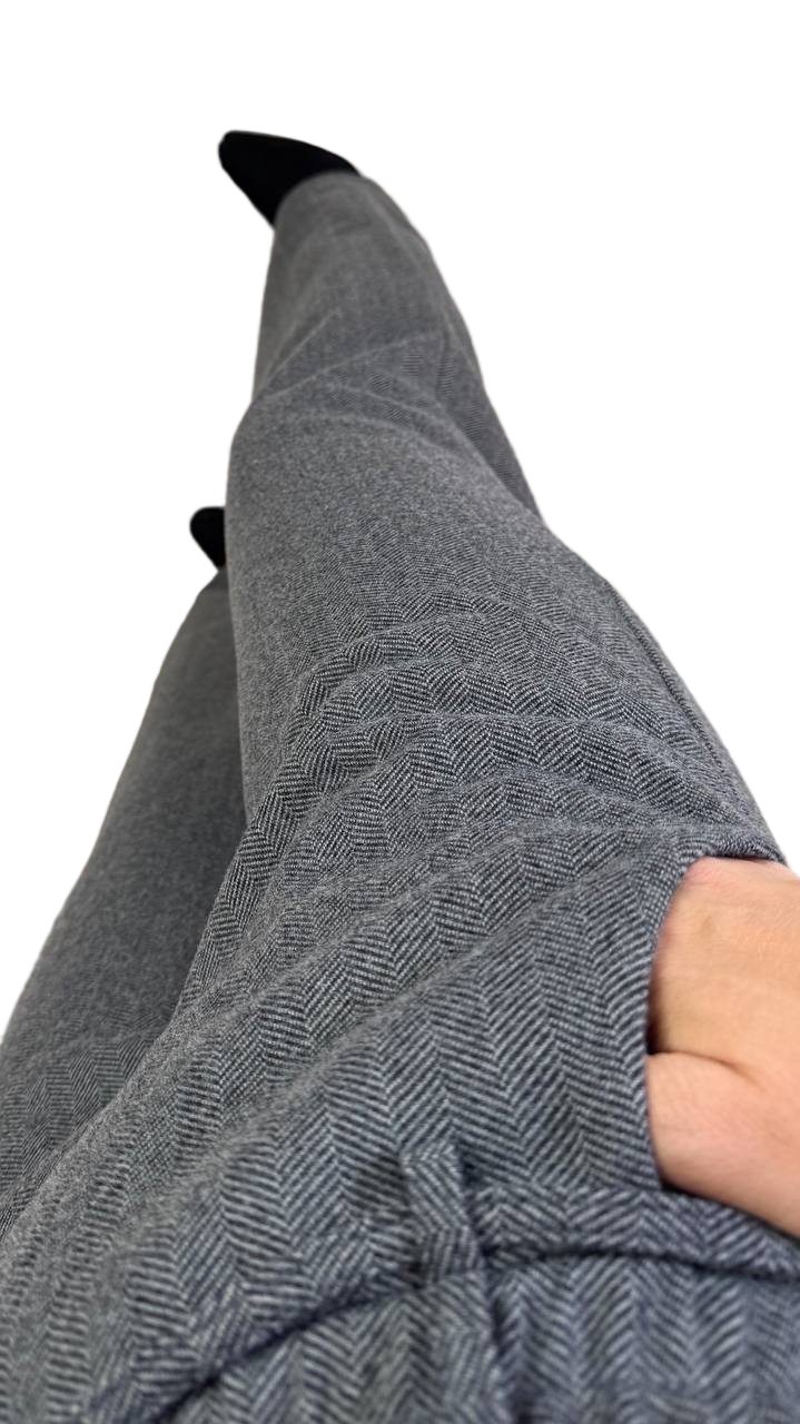 Gray herringbone pants with a person wearing them on a white background
