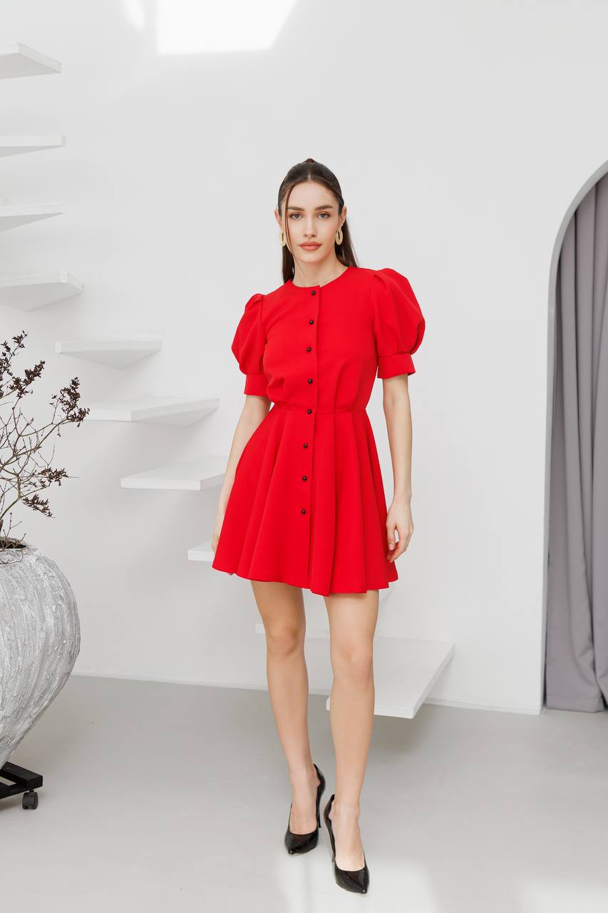 Woman wearing a red dress in a minimalistic room.