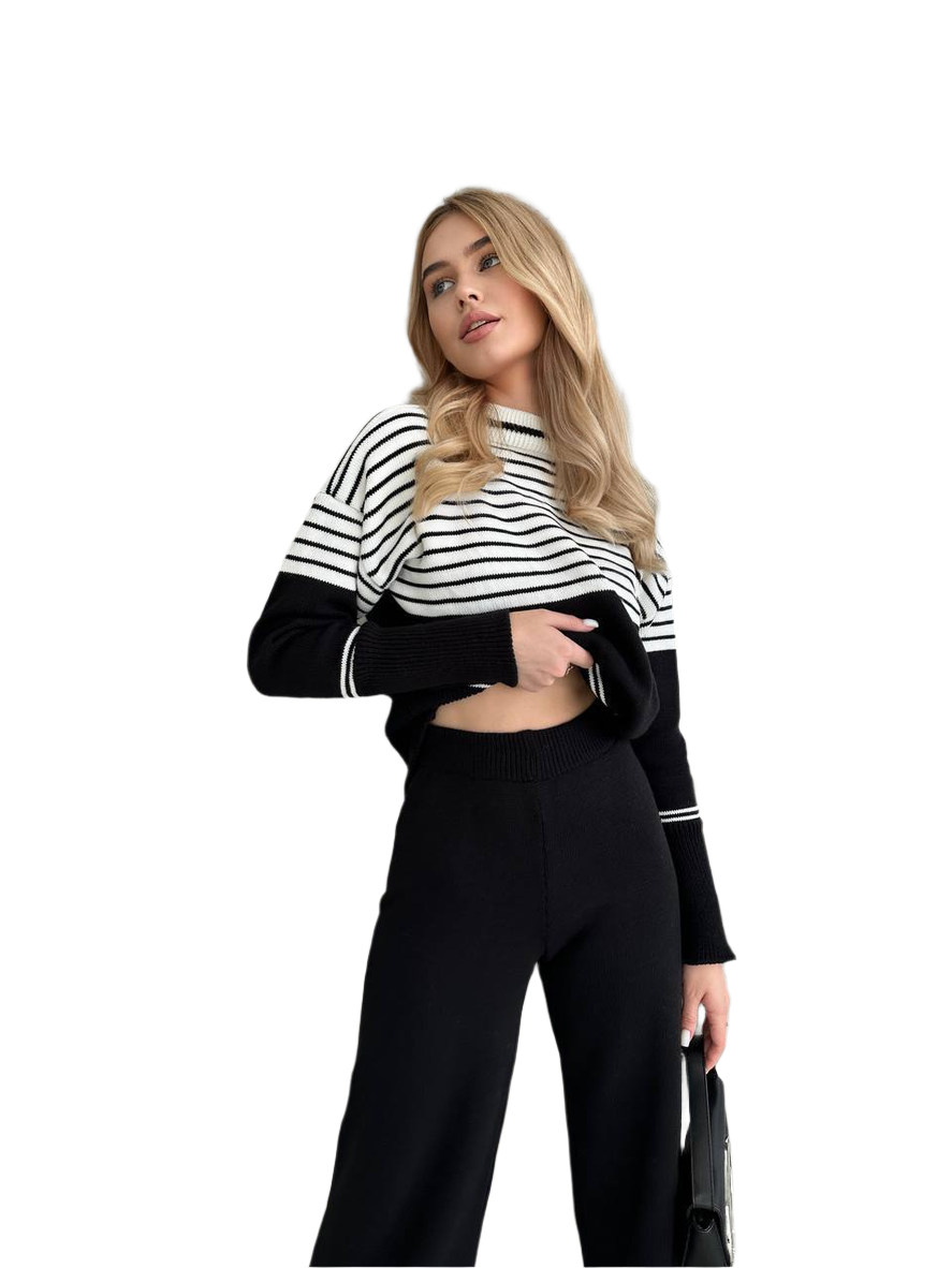 Woman wearing a black and white striped sweater and black pants on a white background