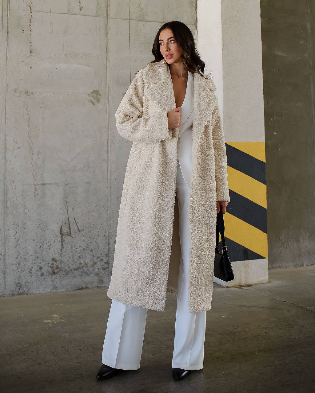 Woman wearing a long beige coat in an urban setting