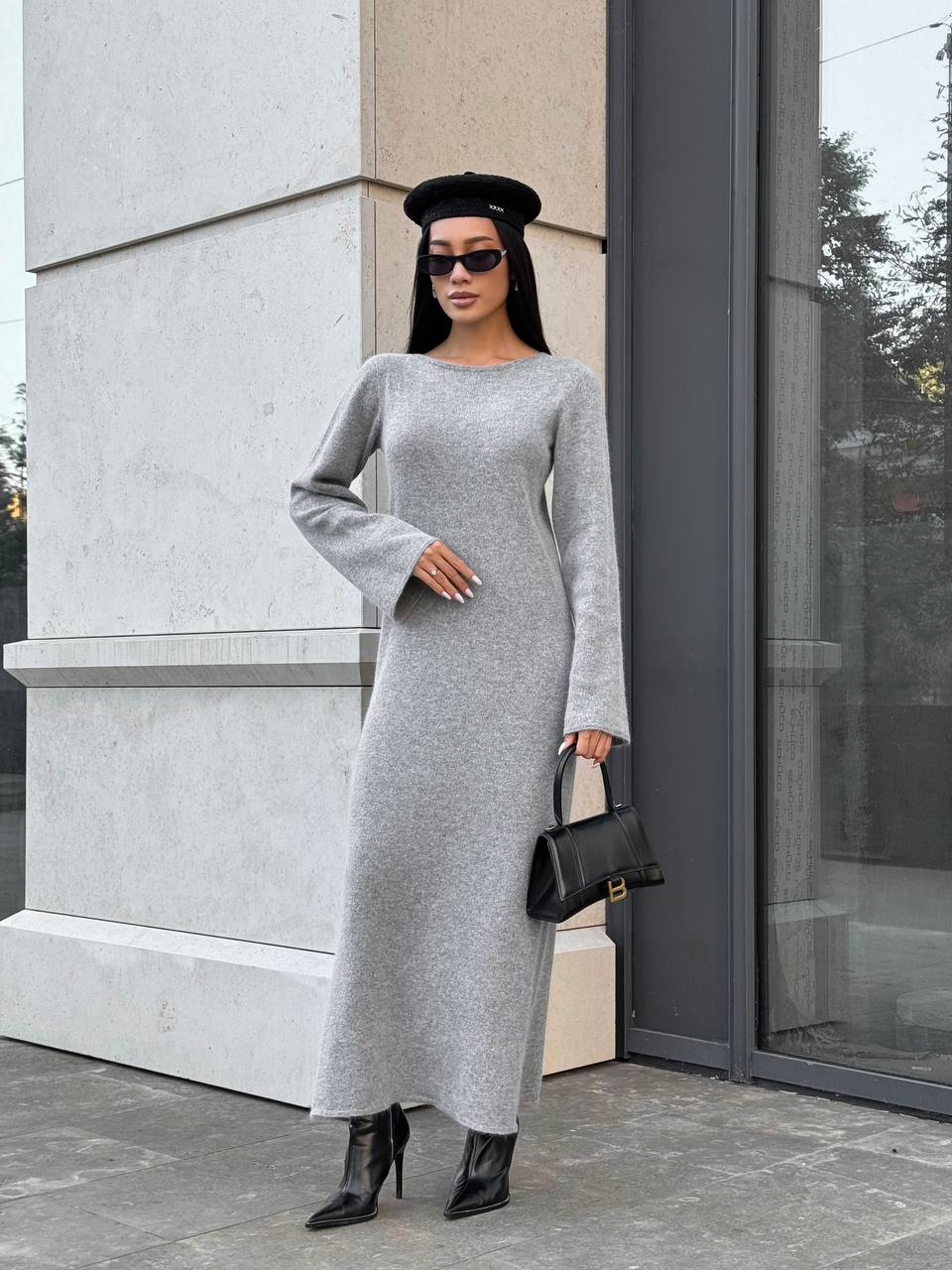 Woman in a gray dress standing outside a building