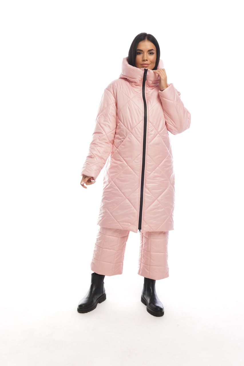 Person wearing a pink puffer coat and pants on a white background
