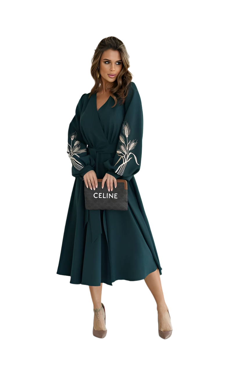 Woman wearing a dark green dress with floral embellishments, holding a Celine handbag on a white background.
