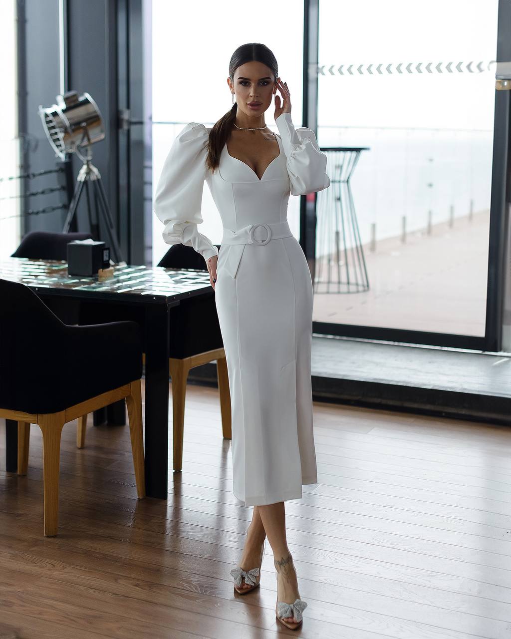 Woman in a white dress standing in a modern interior setting