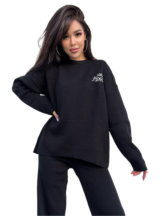 Woman wearing a black sweater with a logo on a white background