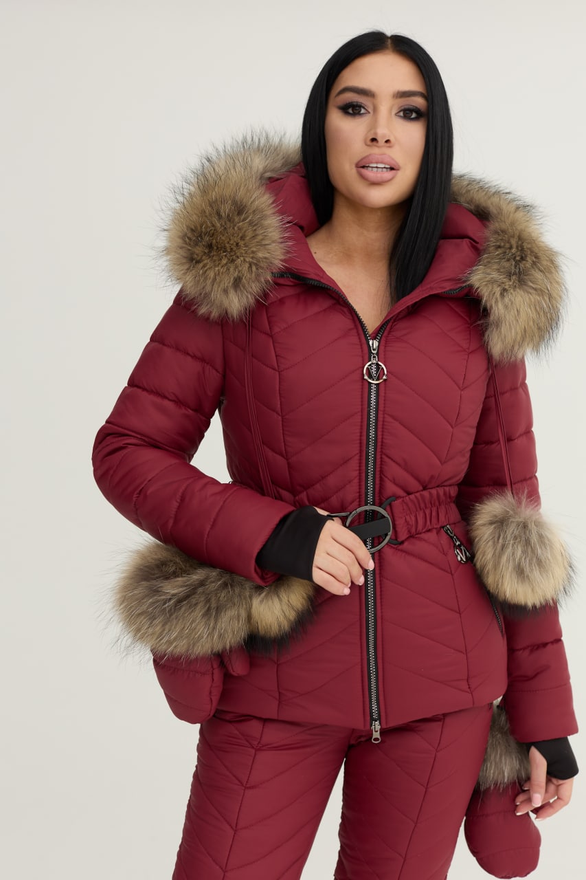 Woman wearing a red puffer jacket with fur trim on a white background