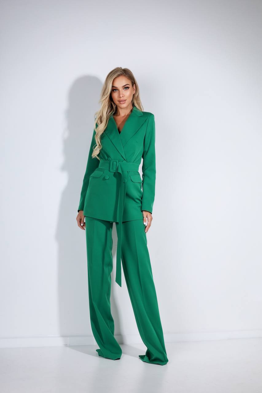 Woman wearing a green suit against a white background