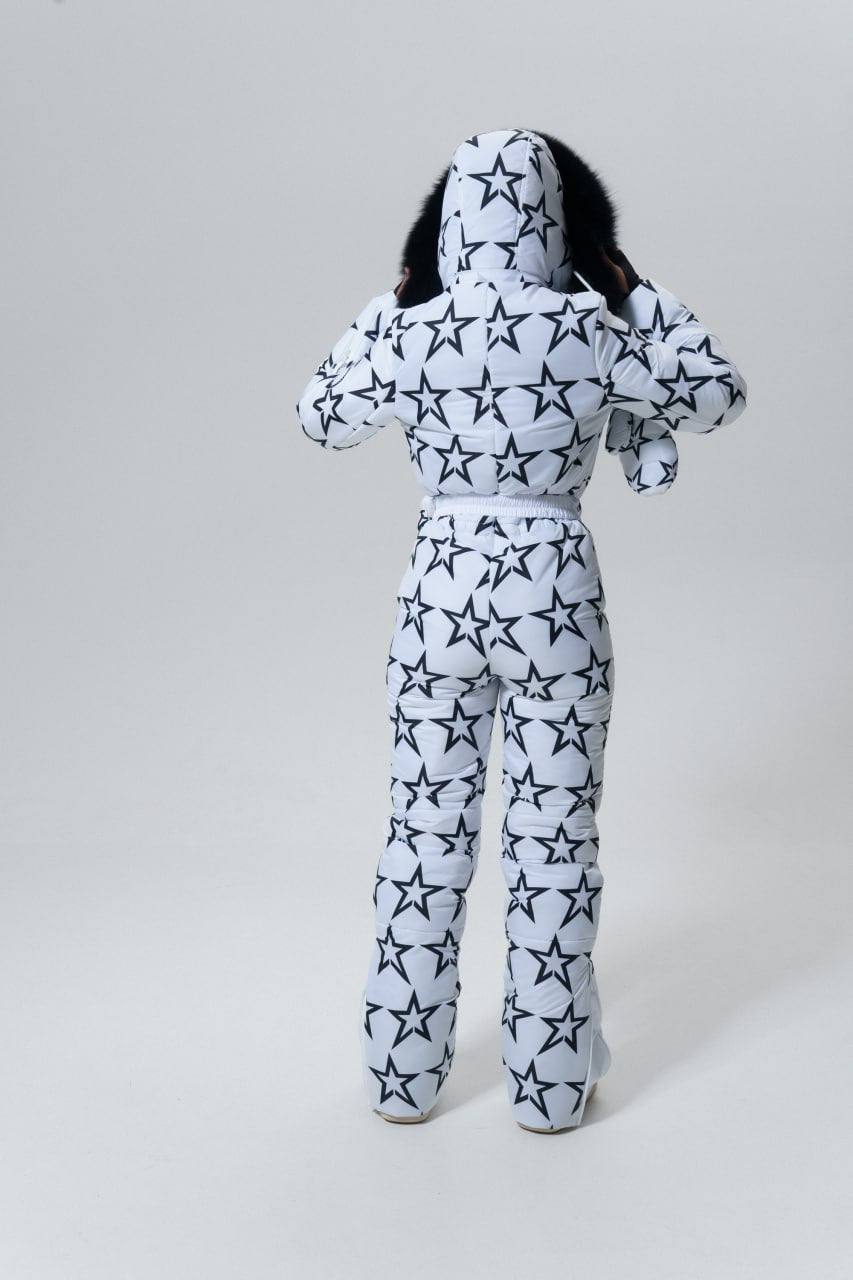 Person wearing a star-patterned onesie on a plain background