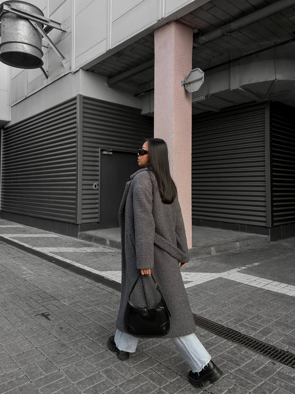 Woman in a long coat walking on a city street